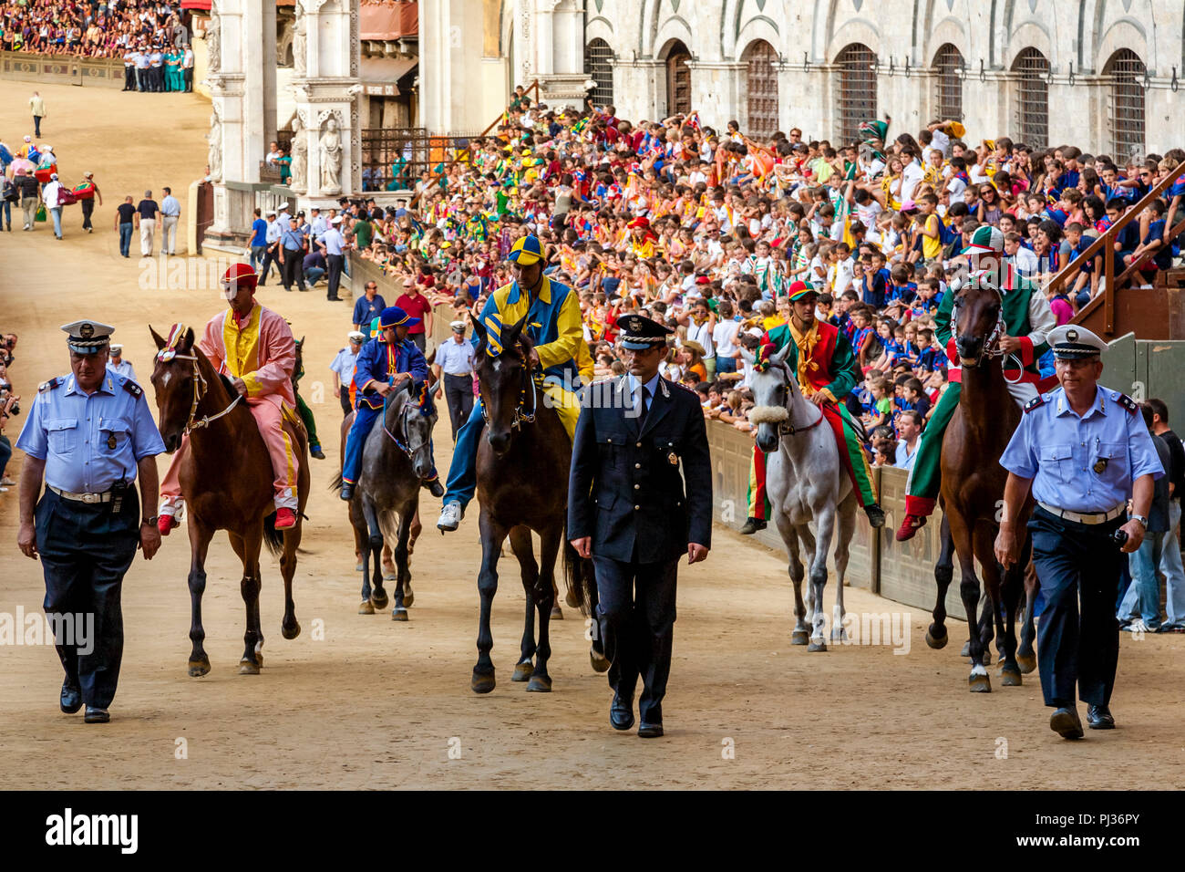 Cavalli e fantini da ciascuna delle dieci Contrade concorrenti sono portato fuori in Piazza del Campo per una gara in prova, il Palio di Siena, Siena, Italia Foto Stock