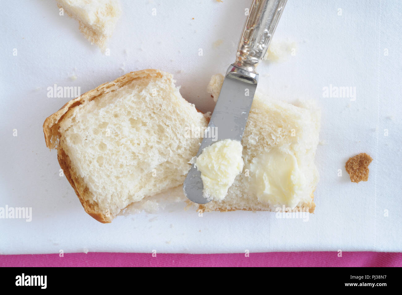 Diffusione di burro sul pane, vista dall'alto Foto Stock