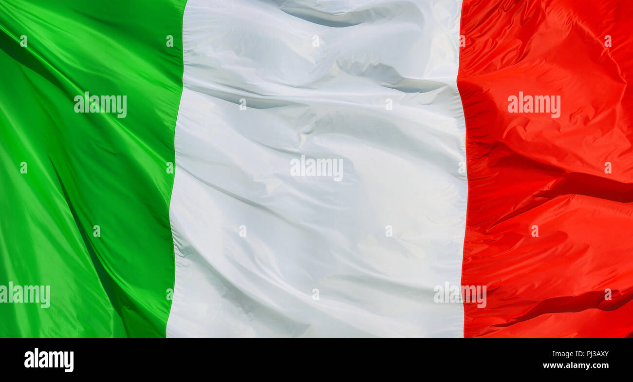 Tricolore (tre colori) Italiano bandiera nazionale che fluttua nel vento come sfondo Foto Stock