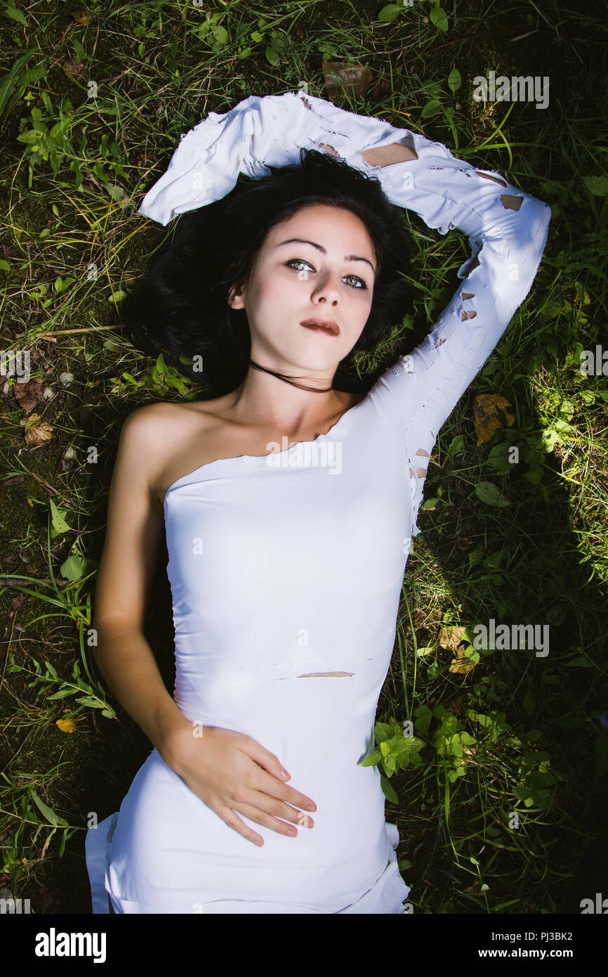 Pallida donna in abito bianco sul terreno oscuro mistero scena Foto stock Alamy