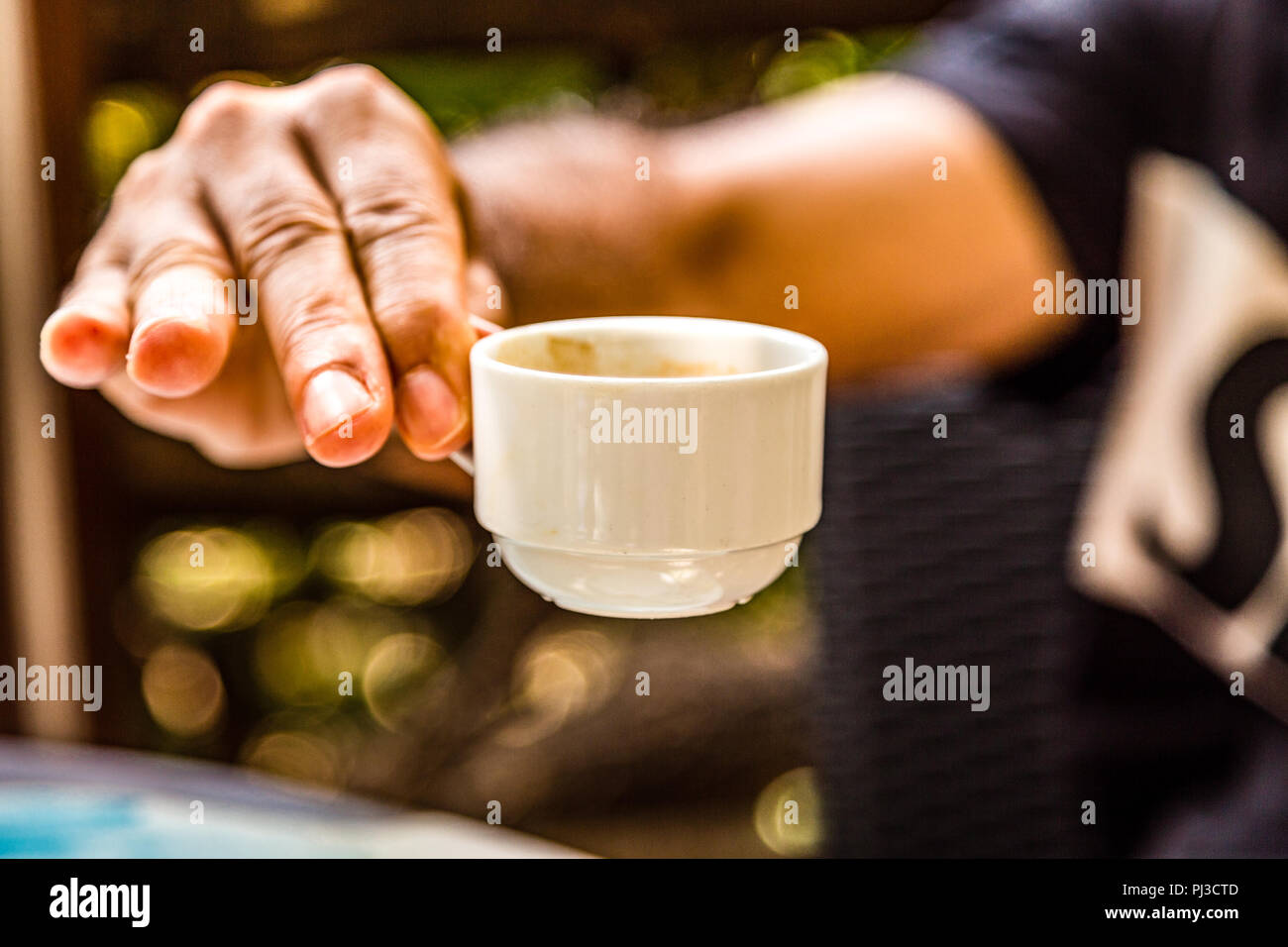 Maschio di mano che regge una piccola tazza del napoletano di caffè espresso Foto Stock
