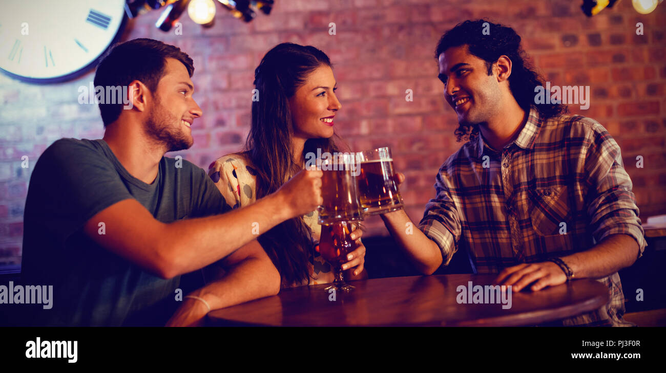 Giovani amici la tostatura boccali da birra Foto Stock