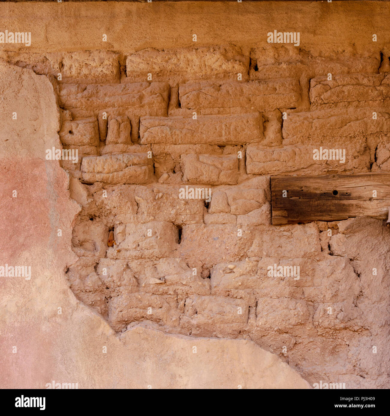 Primo piano della vecchia di mattoni di adobe con il muro di mattoni che indossa il basso. Foto Stock