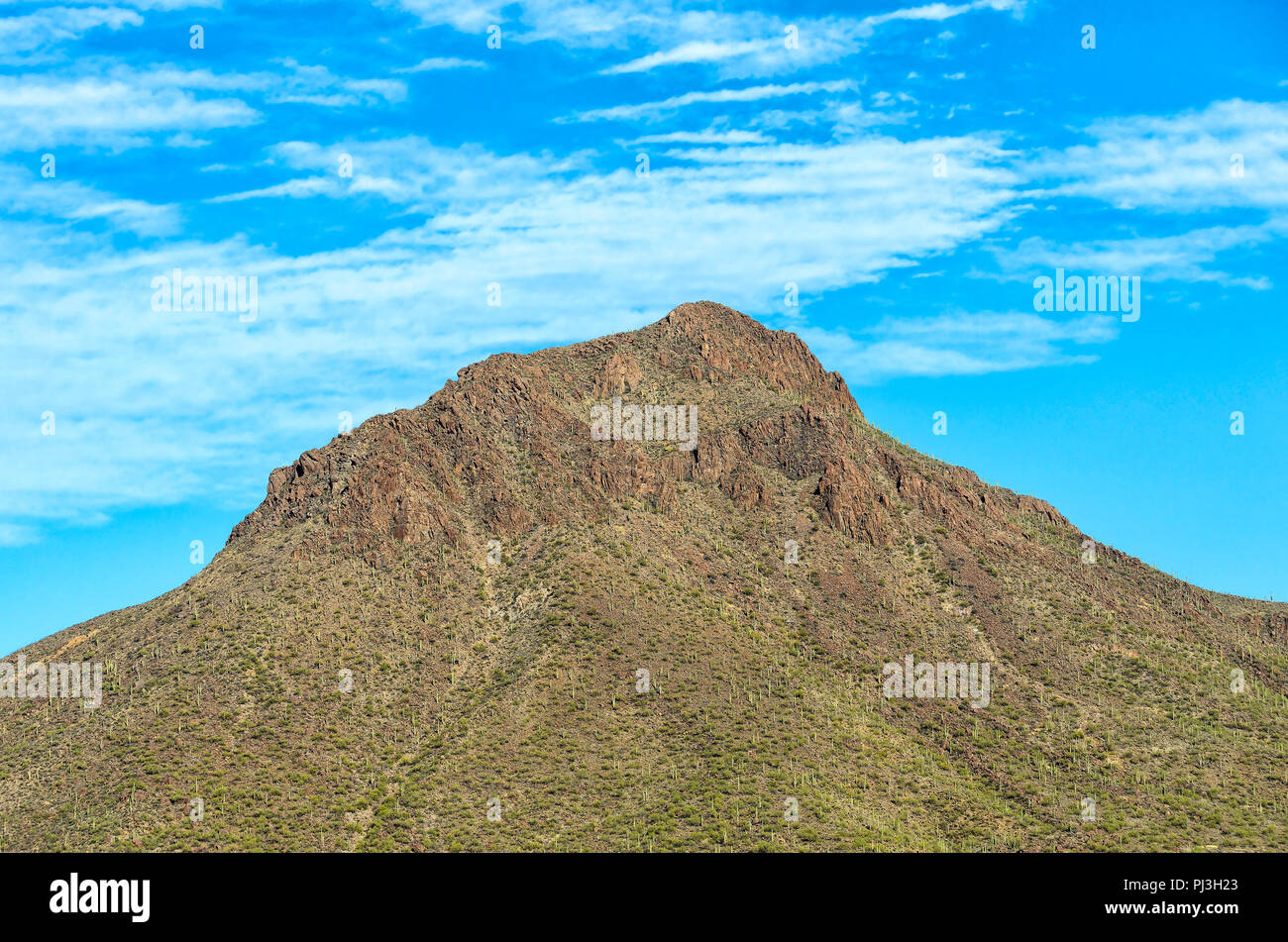 Per la maggior parte di montagna arida sotto il picco luminoso blu cielo con soffici nuvole bianche. Foto Stock