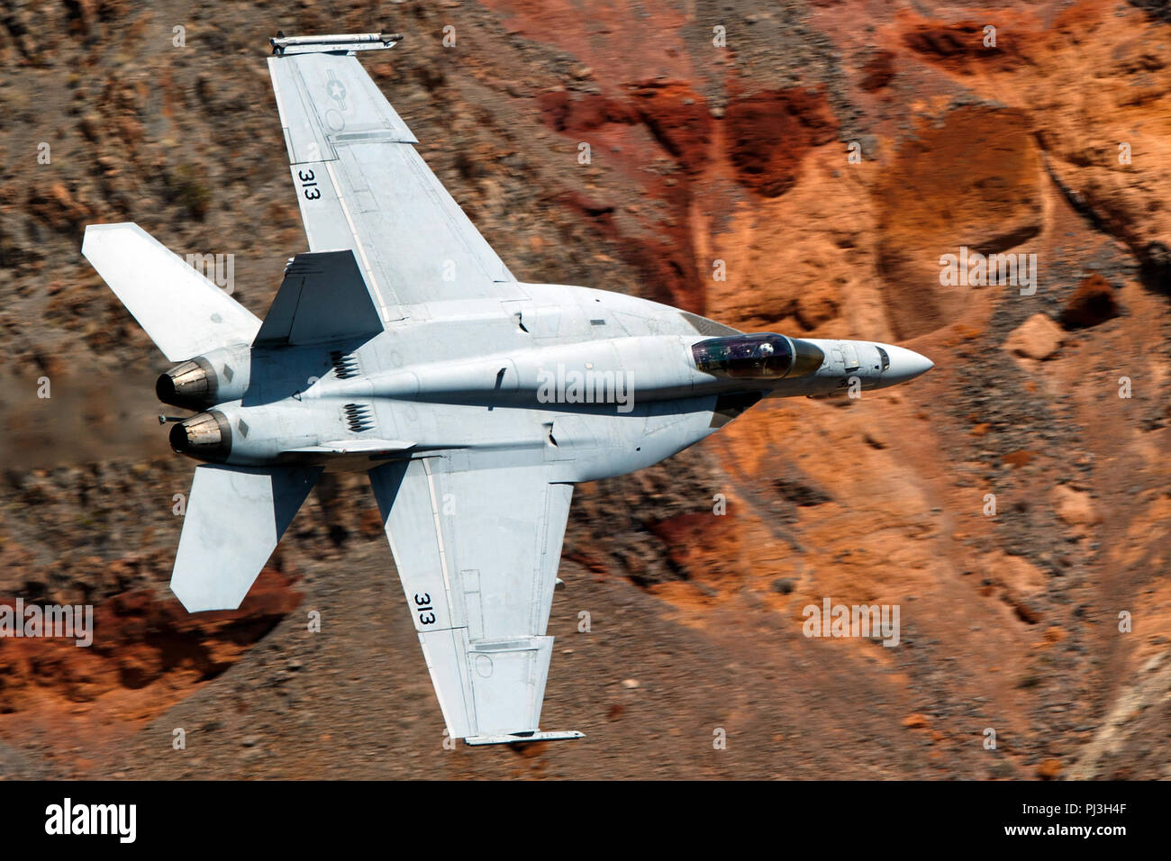 Marina degli Stati Uniti Boeing F/A-18E Super Hornet (lato 313) dal VFA-146 i diamanti blu squadron vola basso livello sulla transizione Jedi attraverso Star Wars Canyon / Rainbow Canyon, il Parco Nazionale della Valle della Morte, Panamint Springs, California, Stati Uniti d'America Foto Stock