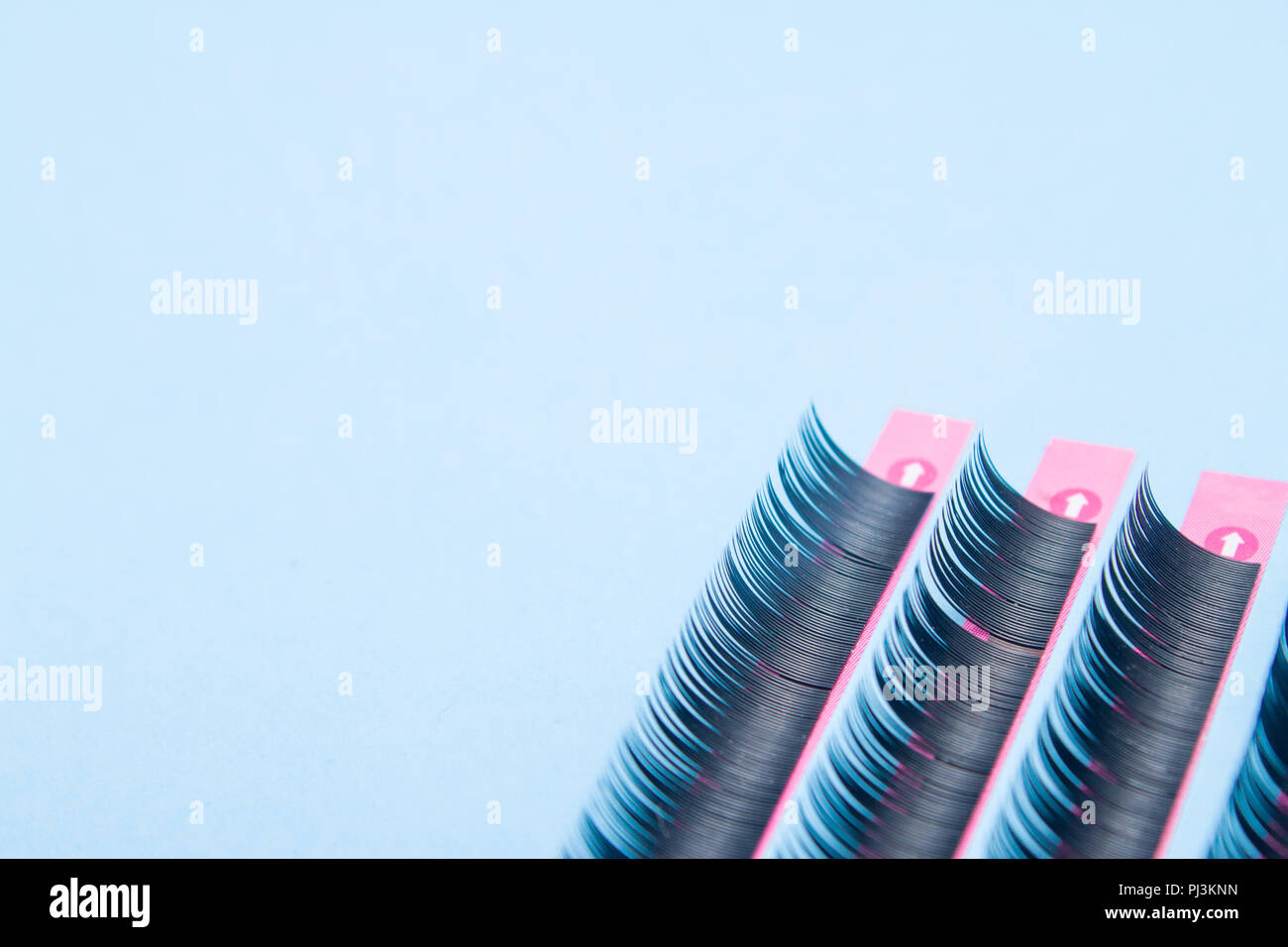 Bellezza e moda concetto - strumenti per extension delle ciglia procedura. artificiale ciglia nere su sfondo blu. copyspace mockup Foto Stock