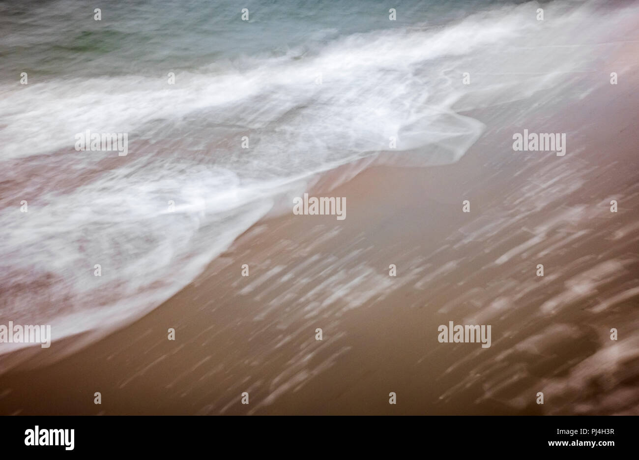 Movimento artistico di sfocare lo sfondo di La schiuma delle onde che lavare fino sulla spiaggia Foto Stock