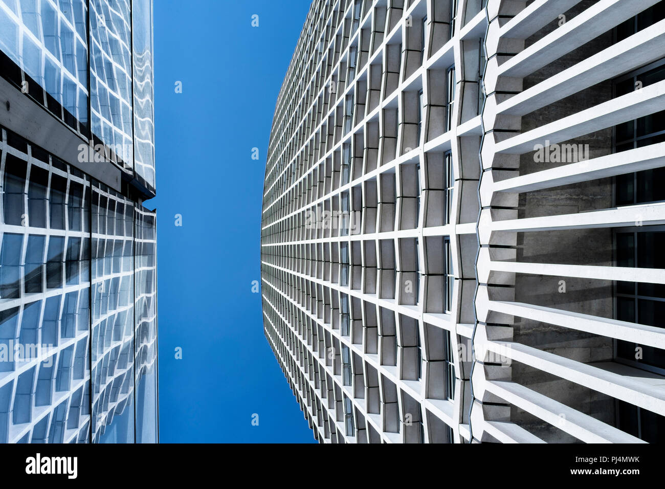 Abstract architettura: Punto centrale edificio con riflessione nella facciata di vetro di Tottenham Court Road stazione della metropolitana di Londra, Regno Unito Foto Stock