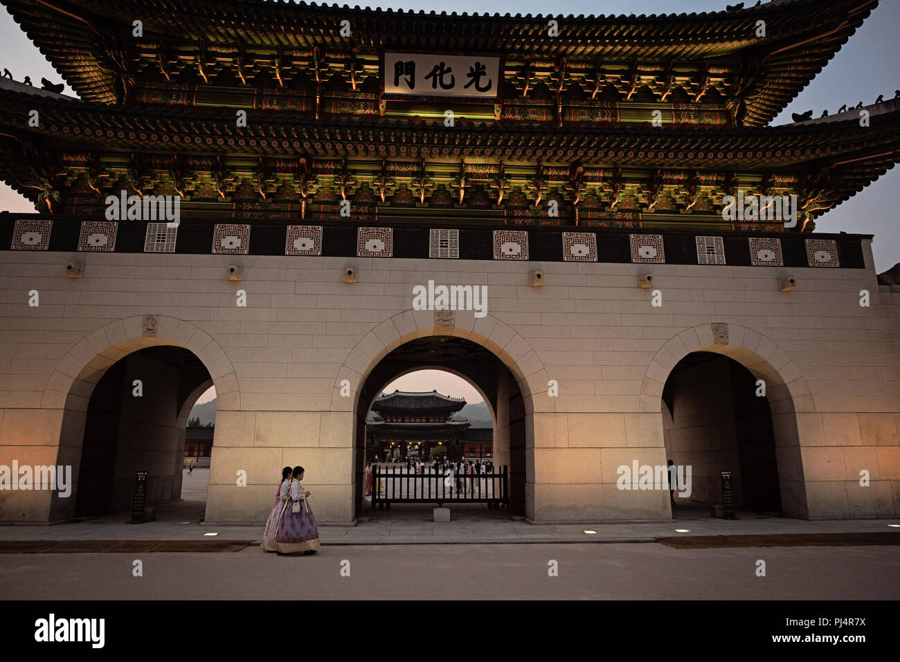 Le donne in Hanbok passando dalla porta di Gwanghwamun, Seoul, Corea del Sud Foto Stock