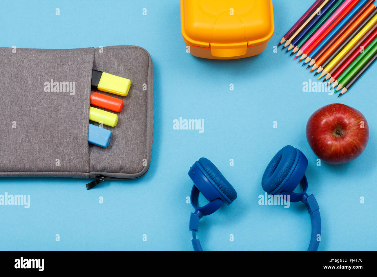 Forniture scolastiche. Sacchetto custodia a matita con colore pennarelli e  marker, scatola di pranzo, matite colorate, apple e cuffie su sfondo blu.  Vista dall'alto. Torna alla Foto stock - Alamy
