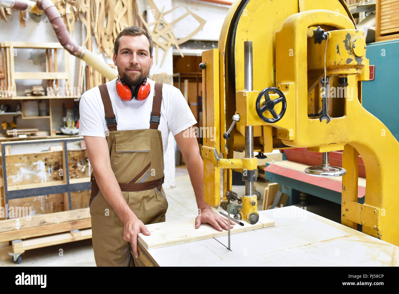 Ritratto di un lavoratore in una falegnameria sul posto di lavoro - macchine per la lavorazione del legno Foto Stock