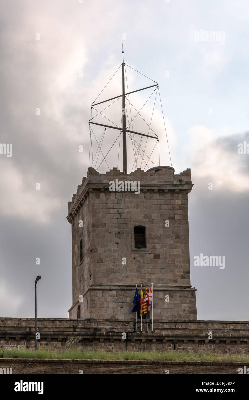 La torretta del Castello di Montjuic contro il cielo nuvoloso. Castello di Montjuic è una vecchia fortezza militare, costruito sulla cima della collina di Montjuic. Ora serve come un civico Foto Stock