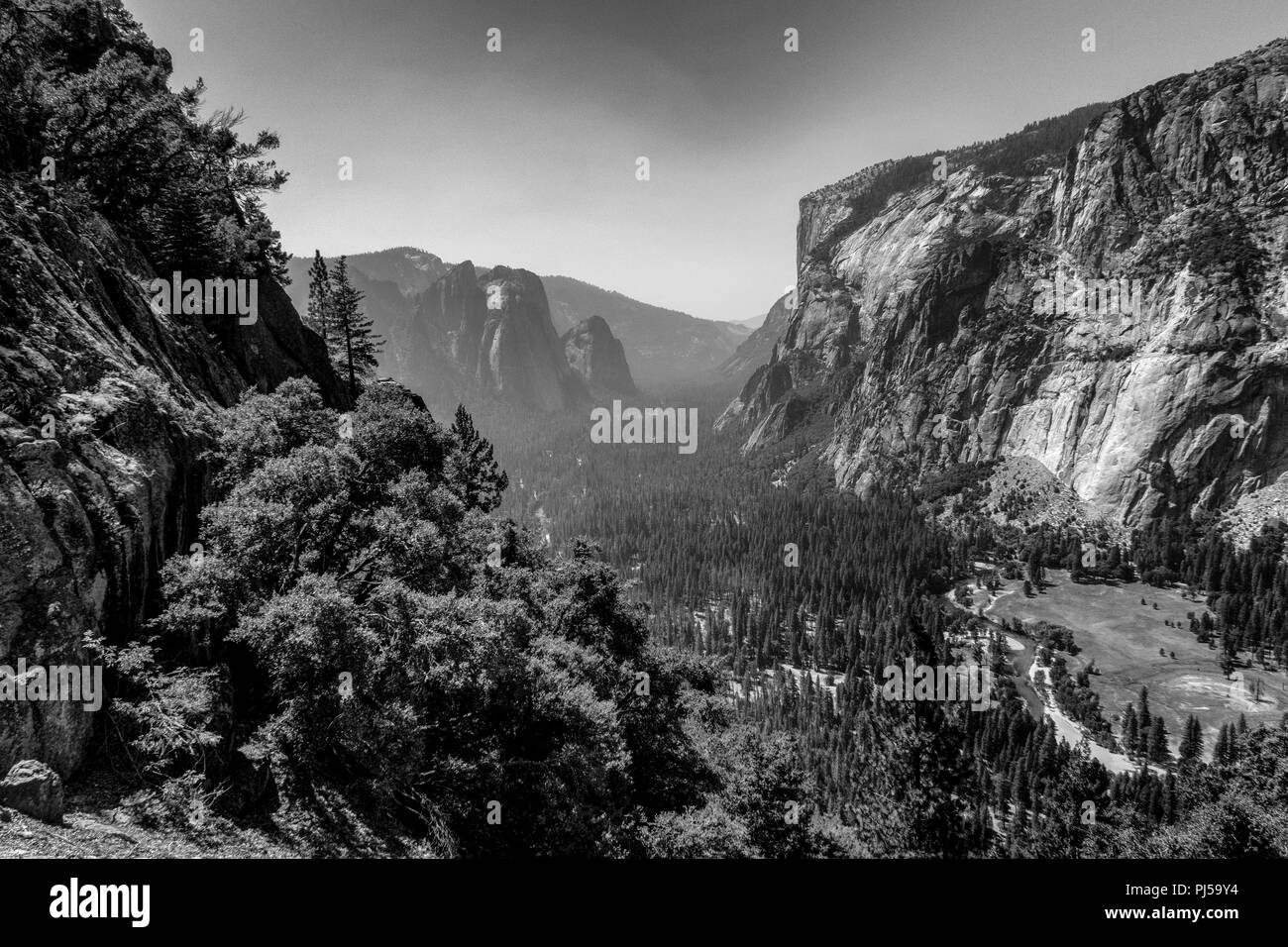 Una vista guardando verso il Parco Nazionale di Yosemite Valley con El Capitan sulla destra nel Parco Nazionale di Yosemite. Il fumo proveniente da incendi indugia nella valle. Foto Stock