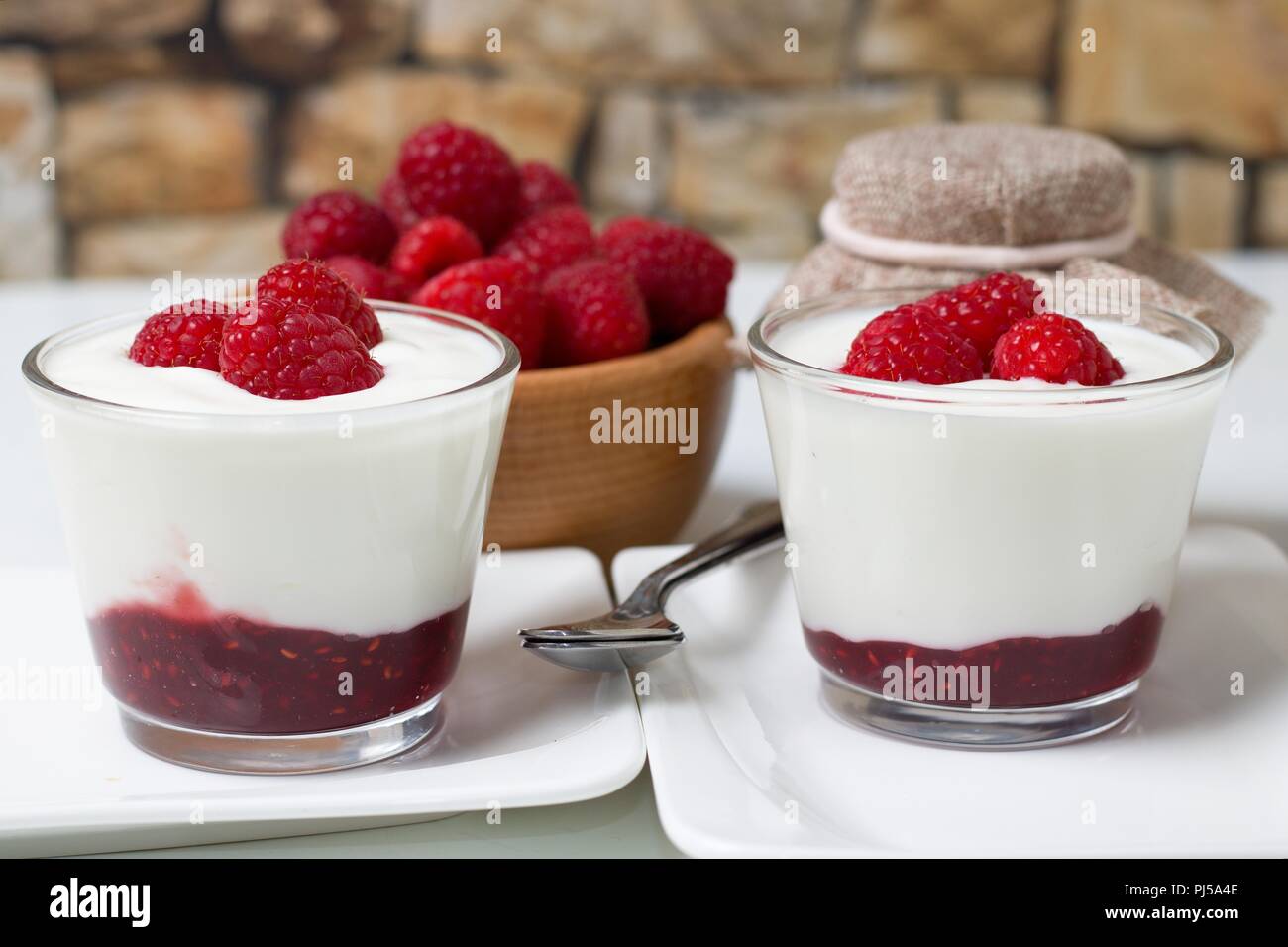 Bella estate il ristoro. Yogurt bianco con marmellata di lamponi freschi e raccolto lamponi Foto Stock