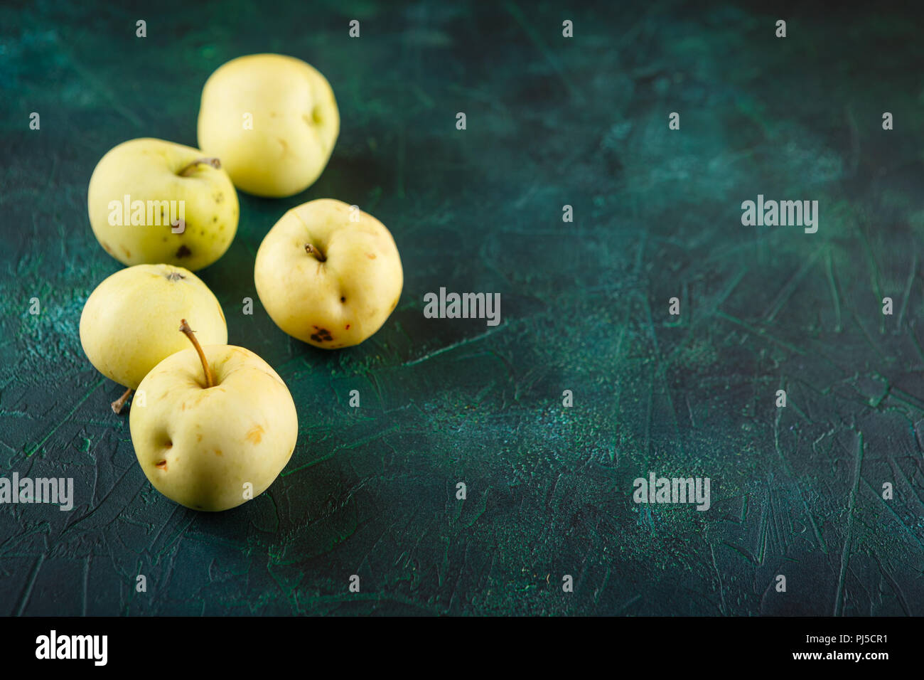 Fresche mele verdi su sfondo verde scuro Foto Stock