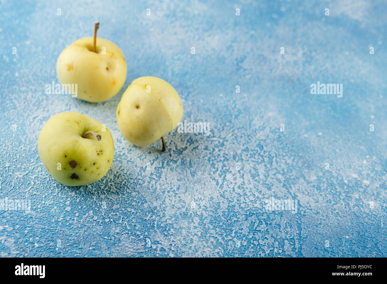 Fresche mele verdi su fondo azzurro Foto Stock