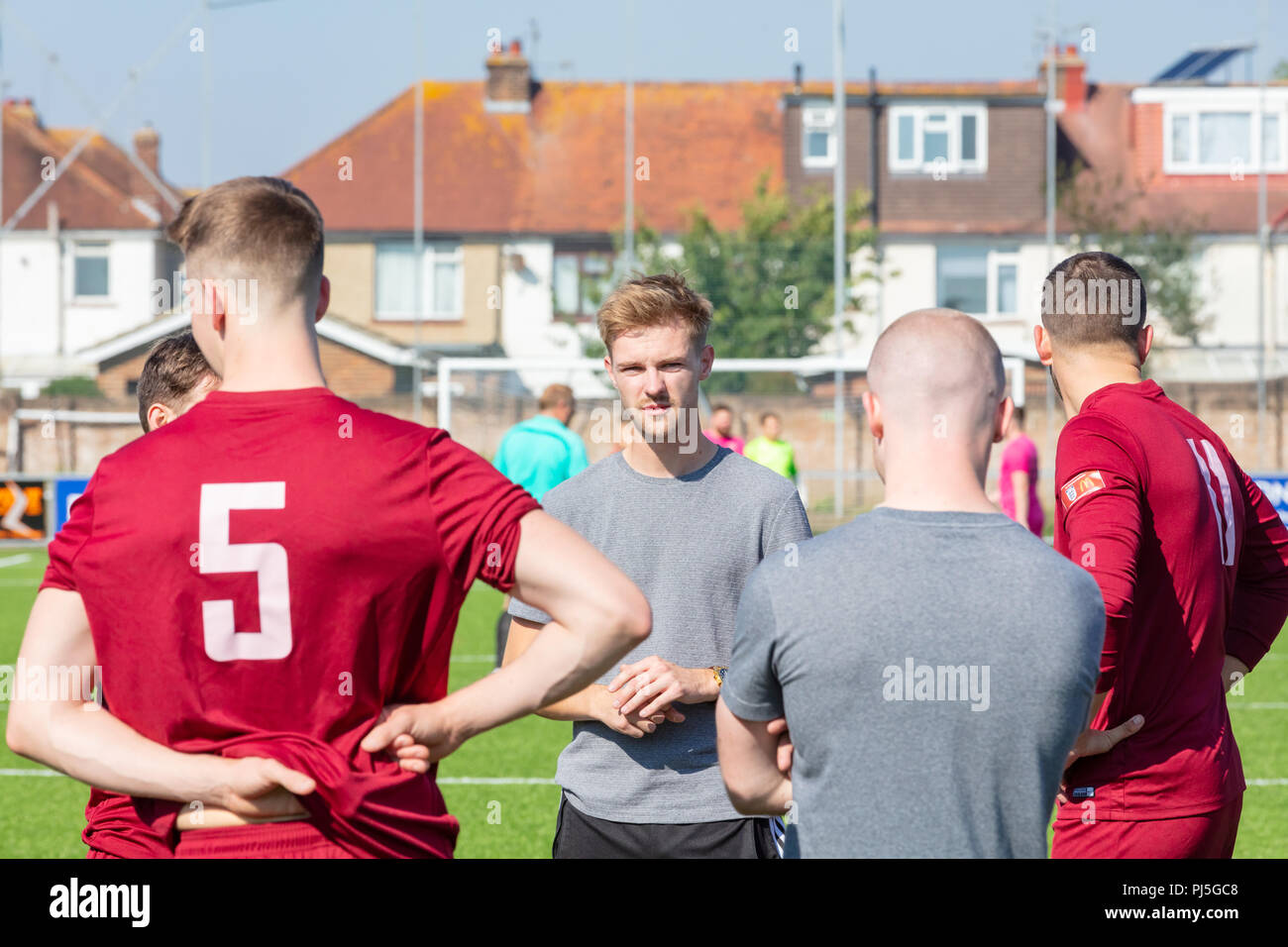 Lancing, Inghilterra; 2 settembre 2018; Manager fornisce team di parlare al gruppo dei maschi di giocatori di calcio prima di una partita Foto Stock