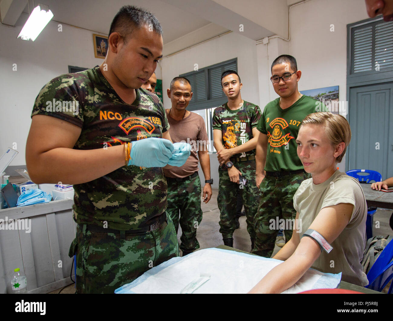 Idaho esercito nazionale Guard Sgt. Mikki Fritz orologi come medico dal Royal Thai Army si prepara a darle un IV come parte di una formazione medica evento durante Hanuman Guardian 2018 agosto 25 presso il Royal Thai dell esercito centro di cavalleria nella provincia di Saraburi. Fritz, una 68W combat medic, è stato per tre paesi negli ultimi quattro anni con l'esercito di Idaho Guardia Nazionale e partecipa in Hanuman Guardian 2018, un esercito bilaterali-esercizio dell'esercito che aumenta la capacità di entrambi gli eserciti pur aumentando anche la interoperabilità tra loro. Foto Stock