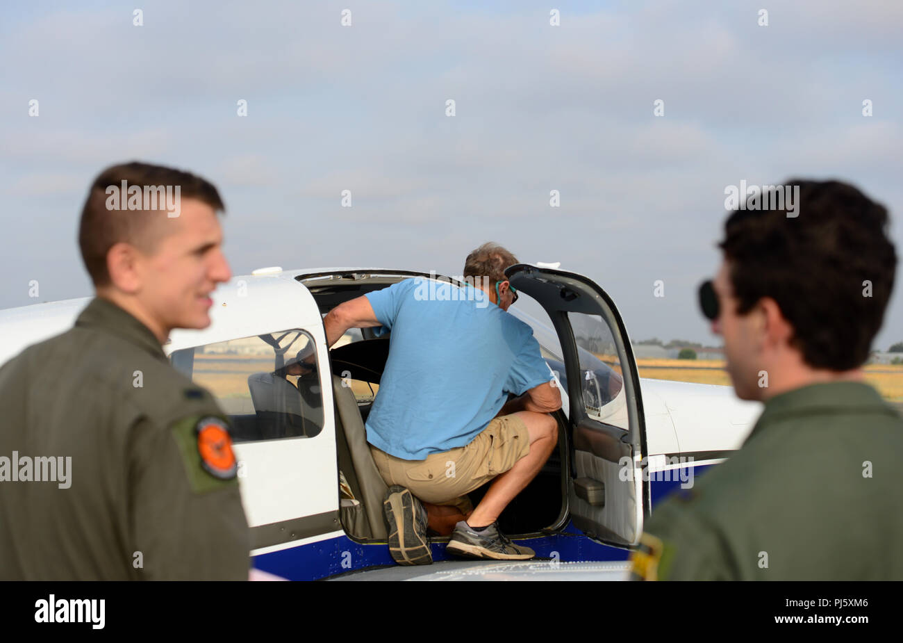 1Lt. Murphy e 1Lt. Miglia, xii squadrone di ricognizione RQ-4 piloti, guarda come Craig Calhoun, Beale Aero Club istruttore, esegue le ispezioni di preflight Agosto 27, 2018 in Olivehurst, California. Il XII RS ha iniziato un compagno Trainer programma dove RQ-4 Global Hawk piloti volano aeromobili con equipaggio. (U.S. Air Force foto di Airman 1. Classe Tristan D. Viglianco) Foto Stock