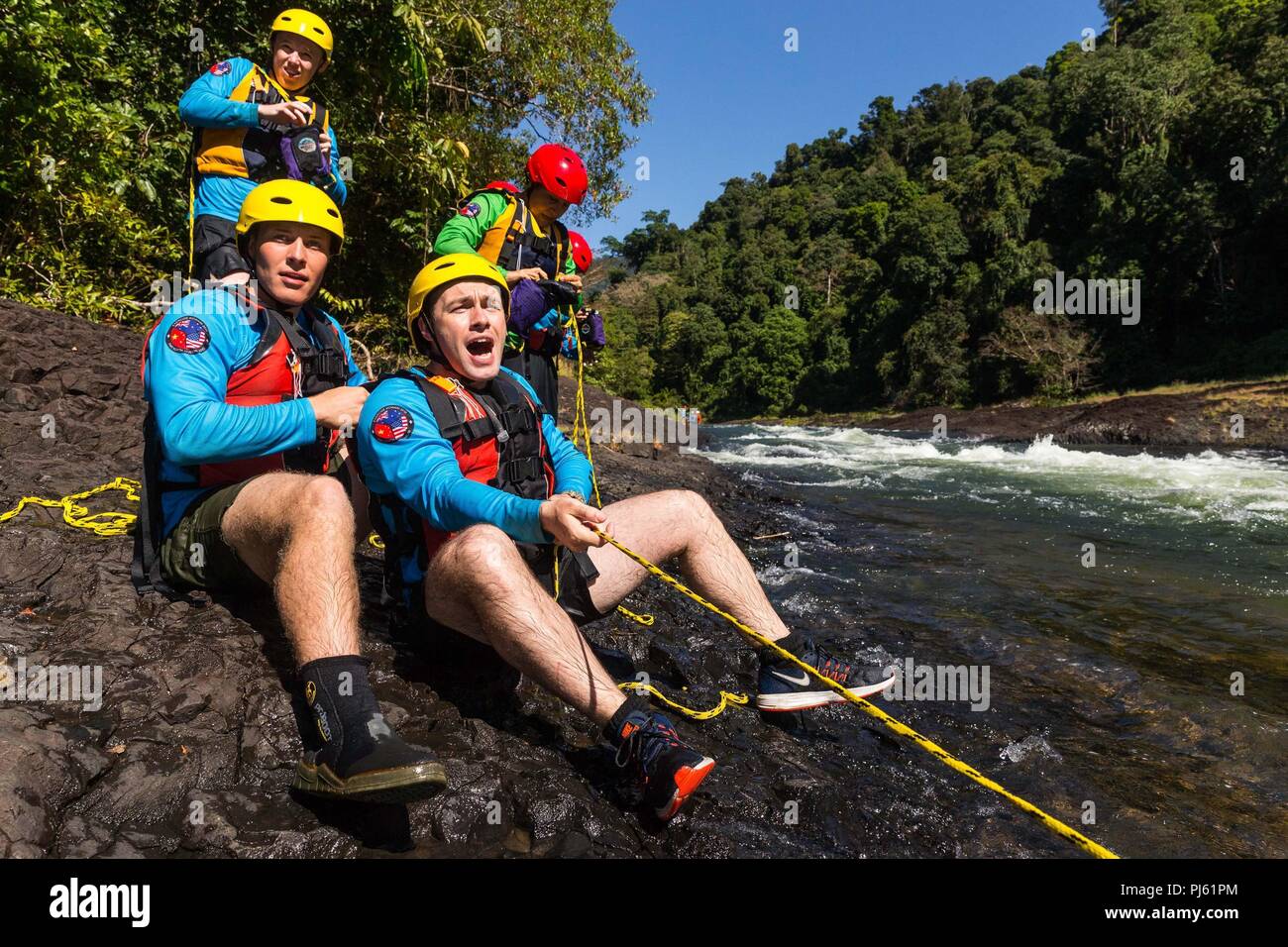 Esercito Australiano officer tenente Benjamin Stark (destra) e della marina degli Stati Uniti Richard corporali Hartzell lavorano insieme per tirare un compagno di squadra dal Fiume Tully durante la negoziazione di acqua la formazione come parte dell esercizio Kowari 2018. Foto Stock