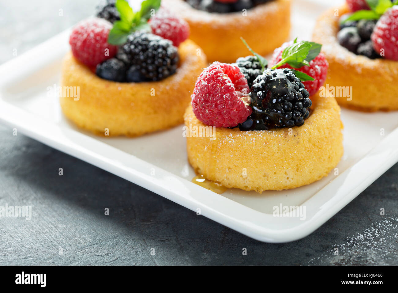 Coppe da dessert con il pan di spagna e frutti di bosco freschi Foto Stock