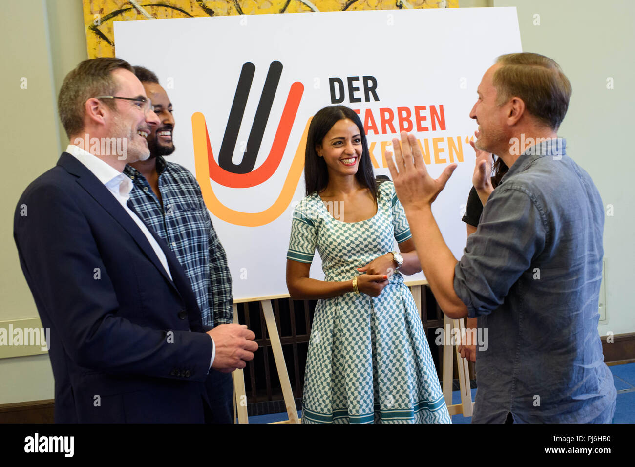 Berlino, Germania. 05 Sep, 2018. 05.09.2018, Berlin: Stefan Franzke (l-r), Direttore Managing Partner di Berlino für Wirtschaft und Technologie GmbH, Fetsum, cantante e musicista, Sawsan Chebli (SPD), Segretario di Stato per l'impegno civico e affari internazionali e Benno Fürmann, attore parla dopo una conferenza stampa per presentare il #Farbenbekennen Award prima di un poster pubblicitario. Il premio è dotato di 6000 euro e sarà premiato il 02.12.2018 per il particolare impegno dei profughi. Credito: Gregor Fischer/dpa/Alamy Live News Foto Stock