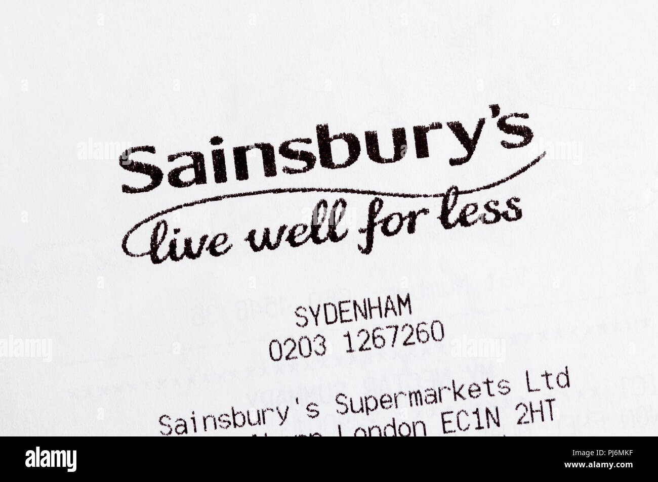 Close-up di Sainsbury's vivere bene per di meno slogan stampati su uno scontrino fiscale. Foto Stock