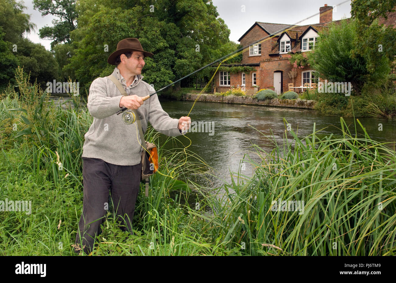 Un uomo di Pesca a Mosca Report di Pesca sul Fiume Test a Mottisford, Hampshire, Regno Unito. Vedere anche è Halford capanno. Foto Stock