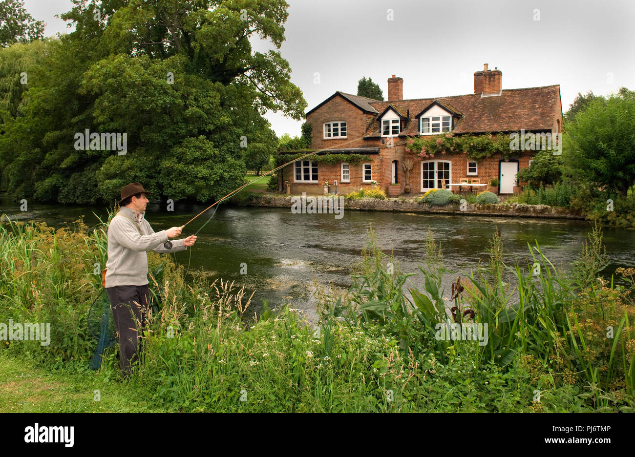 Un uomo di Pesca a Mosca Report di Pesca sul Fiume Test a Mottisford, Hampshire, Regno Unito. Vedere anche è Halford capanno. Foto Stock