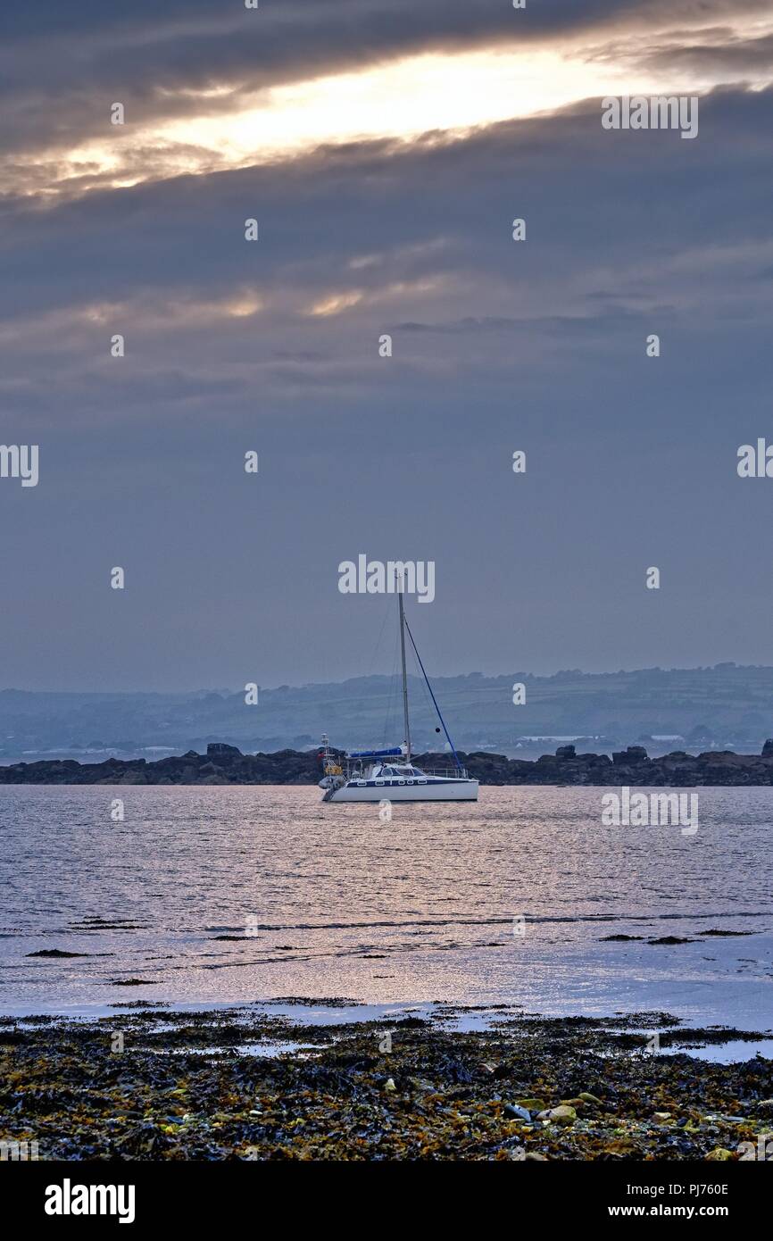 Singolo yacht ormeggiati in Mounts Bay al crepuscolo, Penzance Marazion Cornwall Inghilterra REGNO UNITO Foto Stock