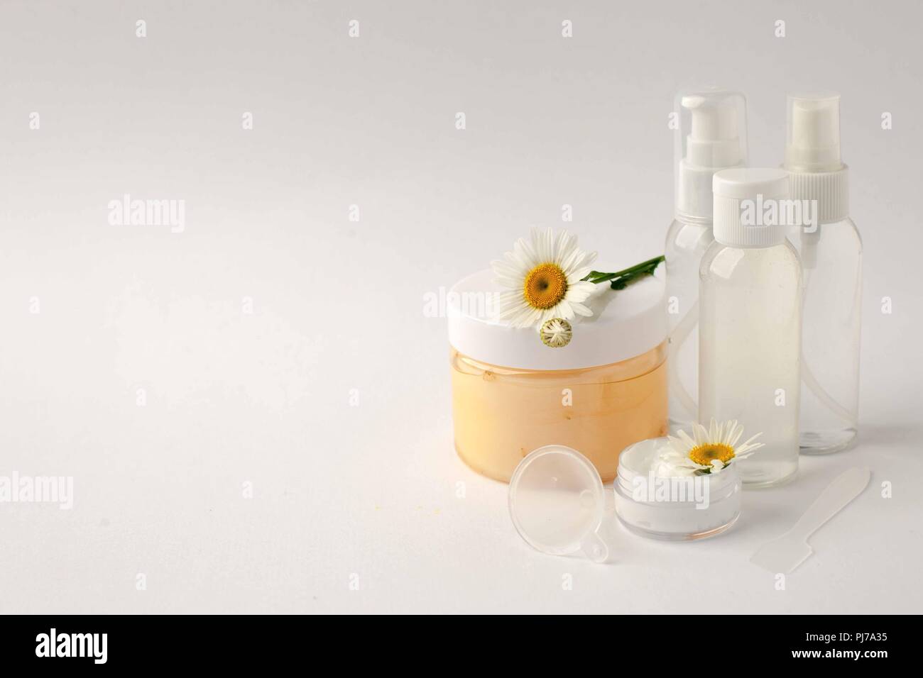 Cosmetici contenitori Vaso con fiori camomole, etichetta vuota package per il branding mock-up, naturale bellezza organica concezione del prodotto Foto Stock