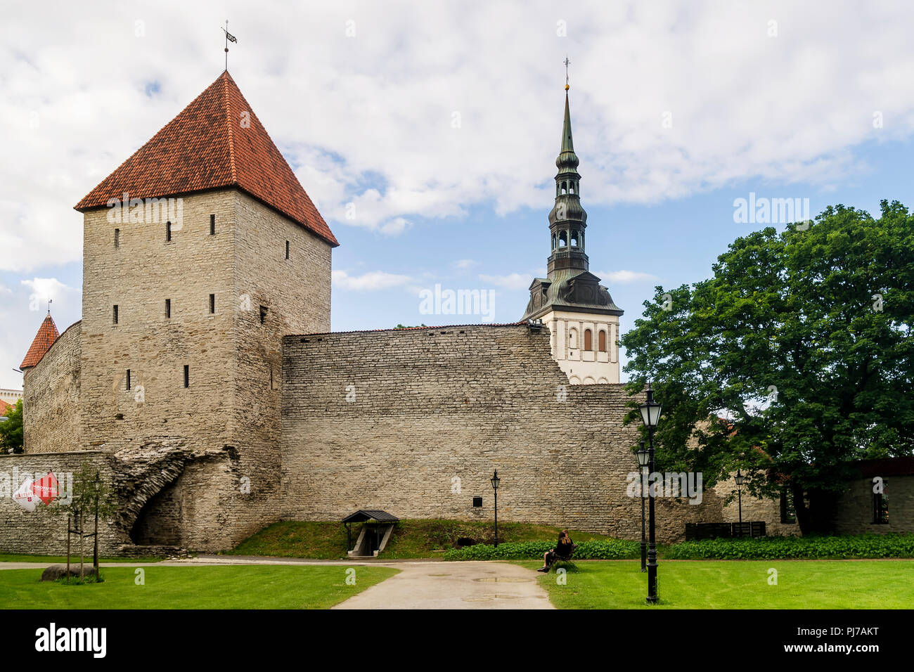 Il campanile della chiesa di San Nicola appare dietro le torri e le mura medievali della città vecchia di Tallinn, Estonia Foto Stock