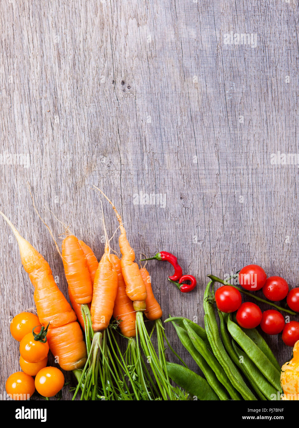 In autunno e in estate le verdure background: pomodori, carote, zucca, i baccelli, peperoncini rossi Foto Stock