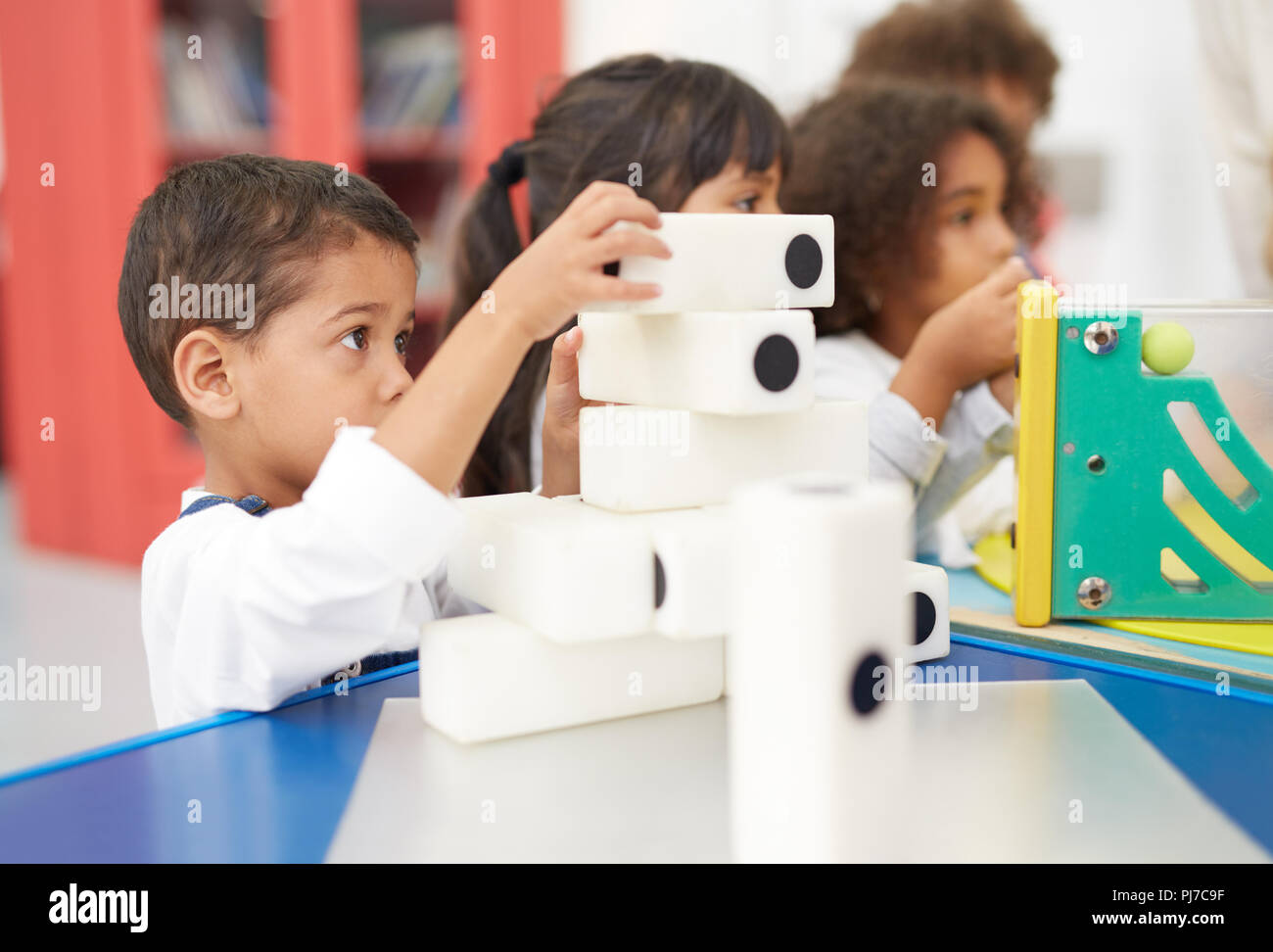 Ragazzo curioso di impilamento dei dominos di grandi dimensioni nel centro di scienze naturali Foto Stock