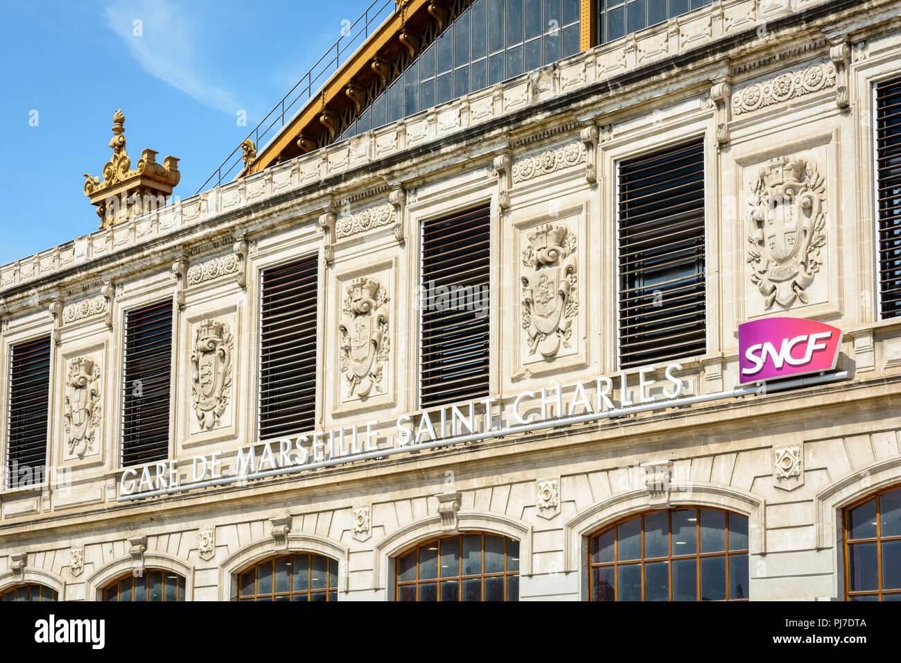 La facciata della stazione di Saint-Charles a Marsiglia, in Francia con il nome della stazione e il logo SNCF sotto gli stemmi delle città servite. Foto Stock