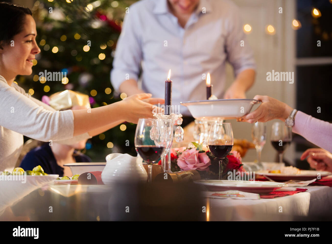 Famiglia passando il cibo, godendo di cena a lume di candela a cena di Natale Foto Stock