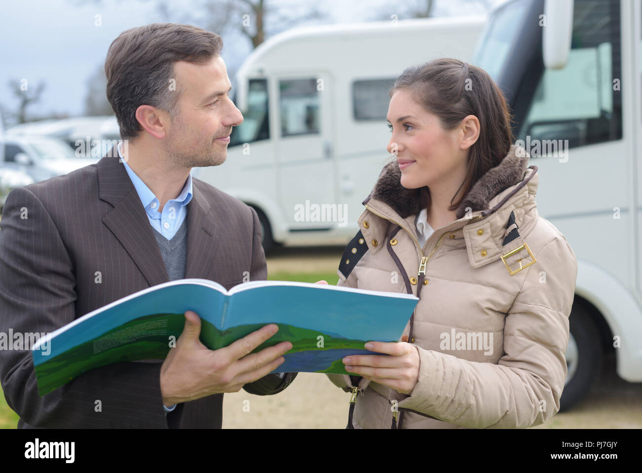 Veicolo venditore mostra brochure per il cliente Foto Stock