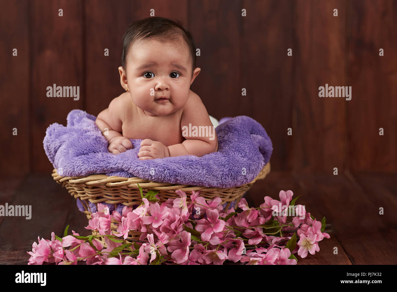 Sorriso felice simpatico baby girl su scuro dello sfondo in legno Foto Stock
