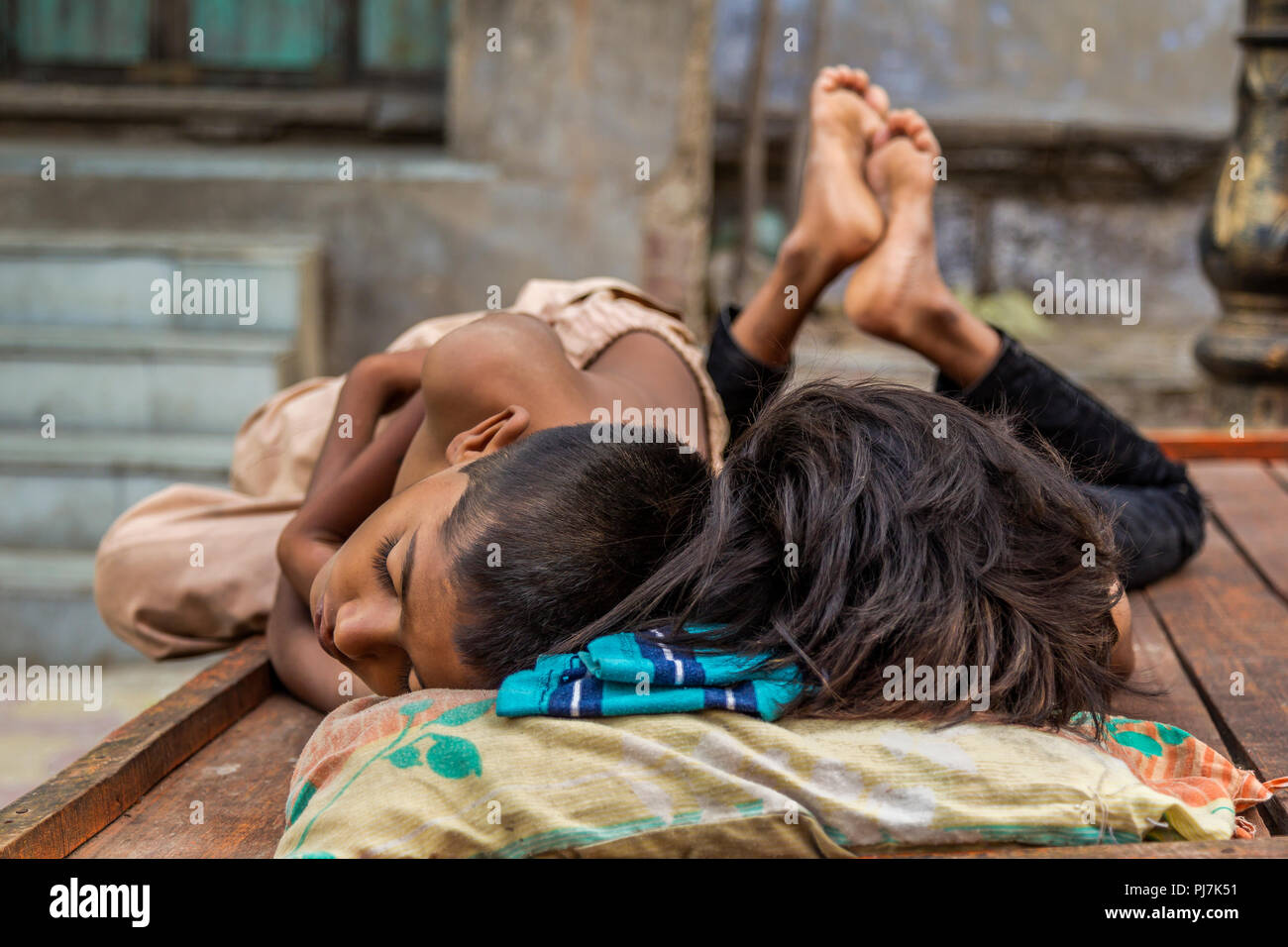 I bambini indiani dormono su un carrello su una strada nella città vecchia di Ahemdabad, Gujrat, India Foto Stock