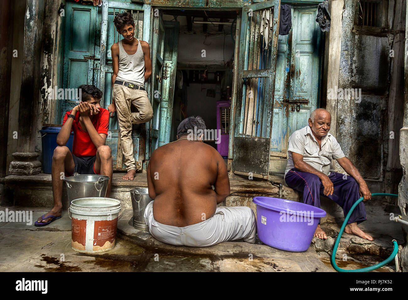 Quattro uomini in attesa di approvvigionamento di acqua Foto Stock