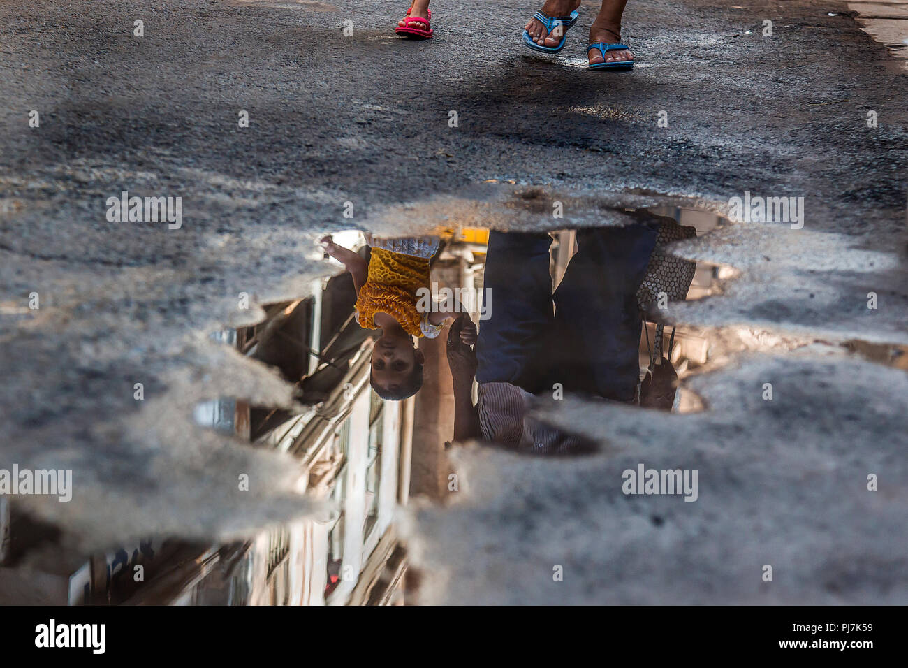 Questa foto è stata presa alla vecchia città di Ahmedabad in estate. in questo pic, la strada è visto bagnato a causa della rottura del tubo acqua Foto Stock