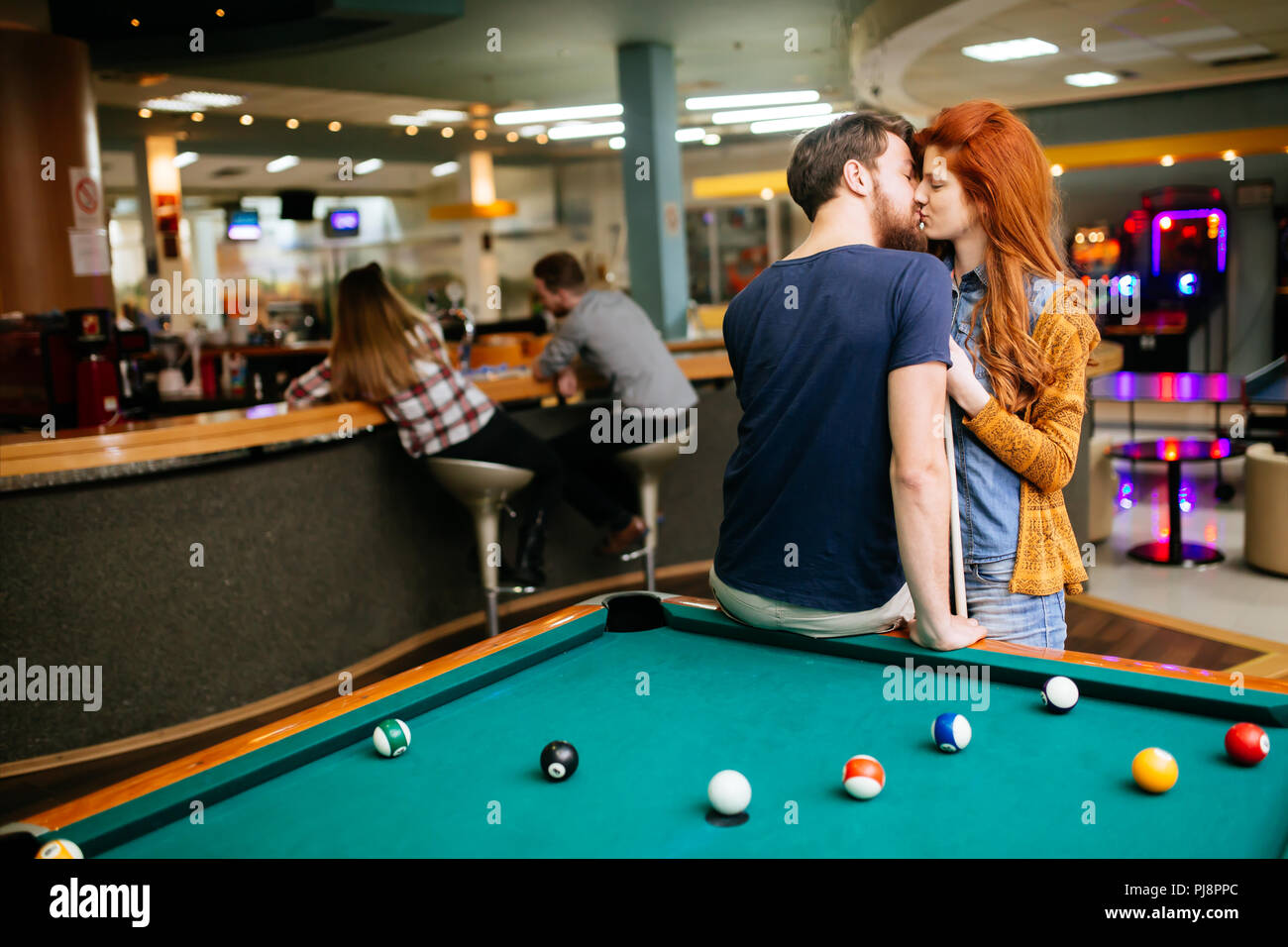 Bella giovane baciare in bar del biliardo Foto Stock