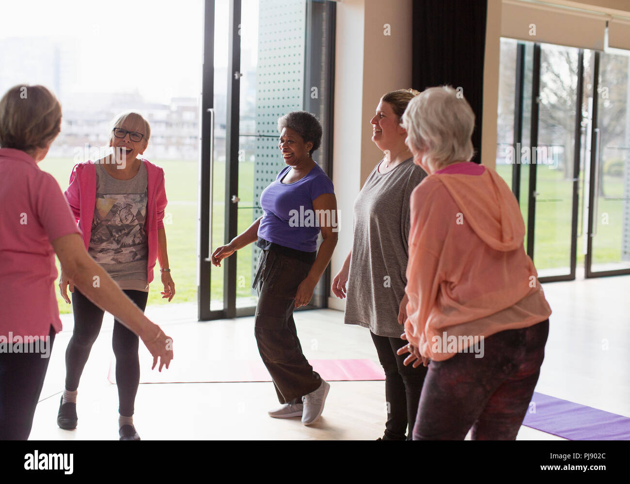 Sorridente active senior donne parlare in classe di esercizio Foto Stock