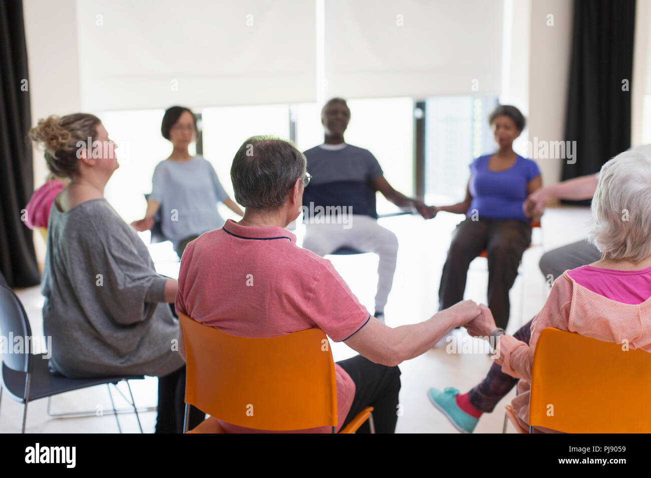 Serena active seniors Holding Hands, meditando in cerchio Foto Stock