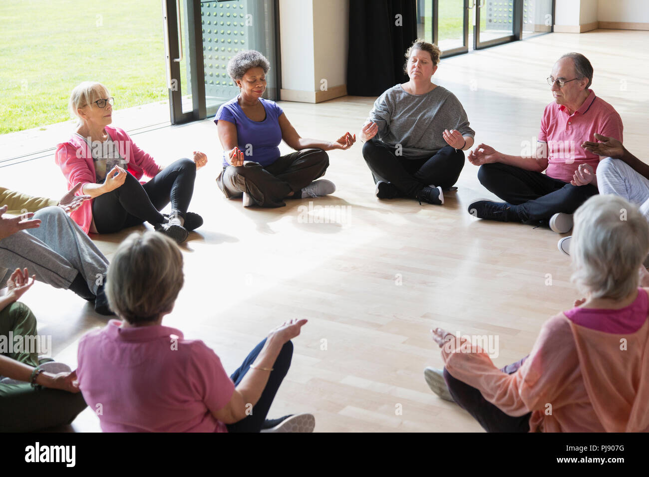 Serena active seniors meditando in cerchio Foto Stock