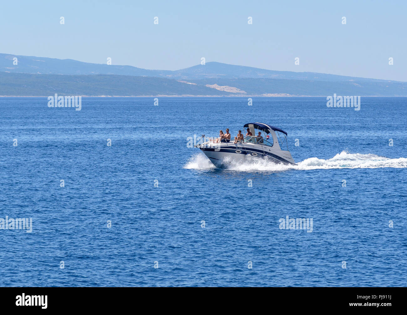 La barca con il popolo di appoggio si muove rapidamente sulle onde del mare. Foto Stock