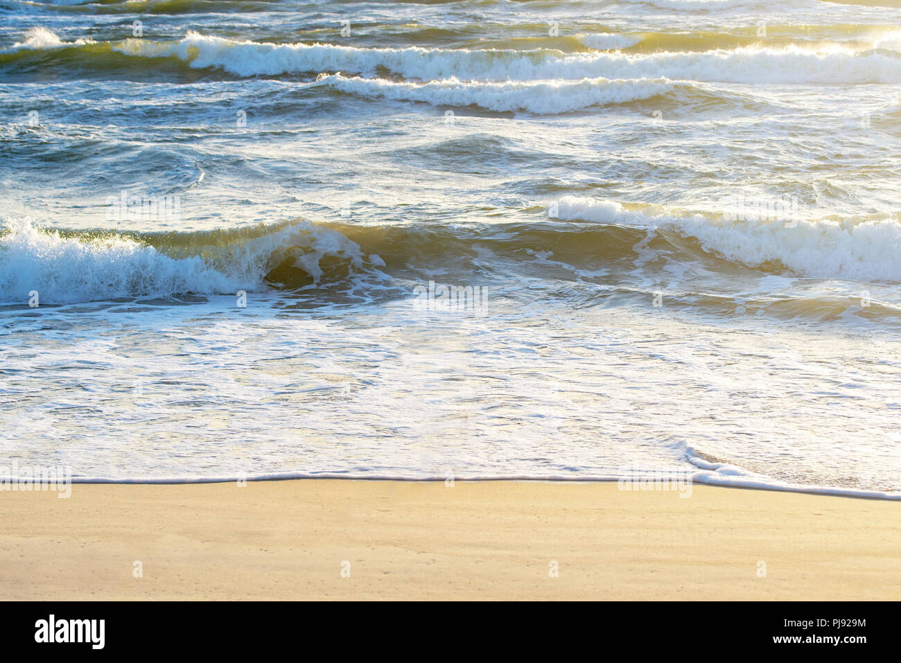 Mare ondeggiante e spiaggia sabbiosa in estate. Vista dalla cima delle dune. Foto Stock