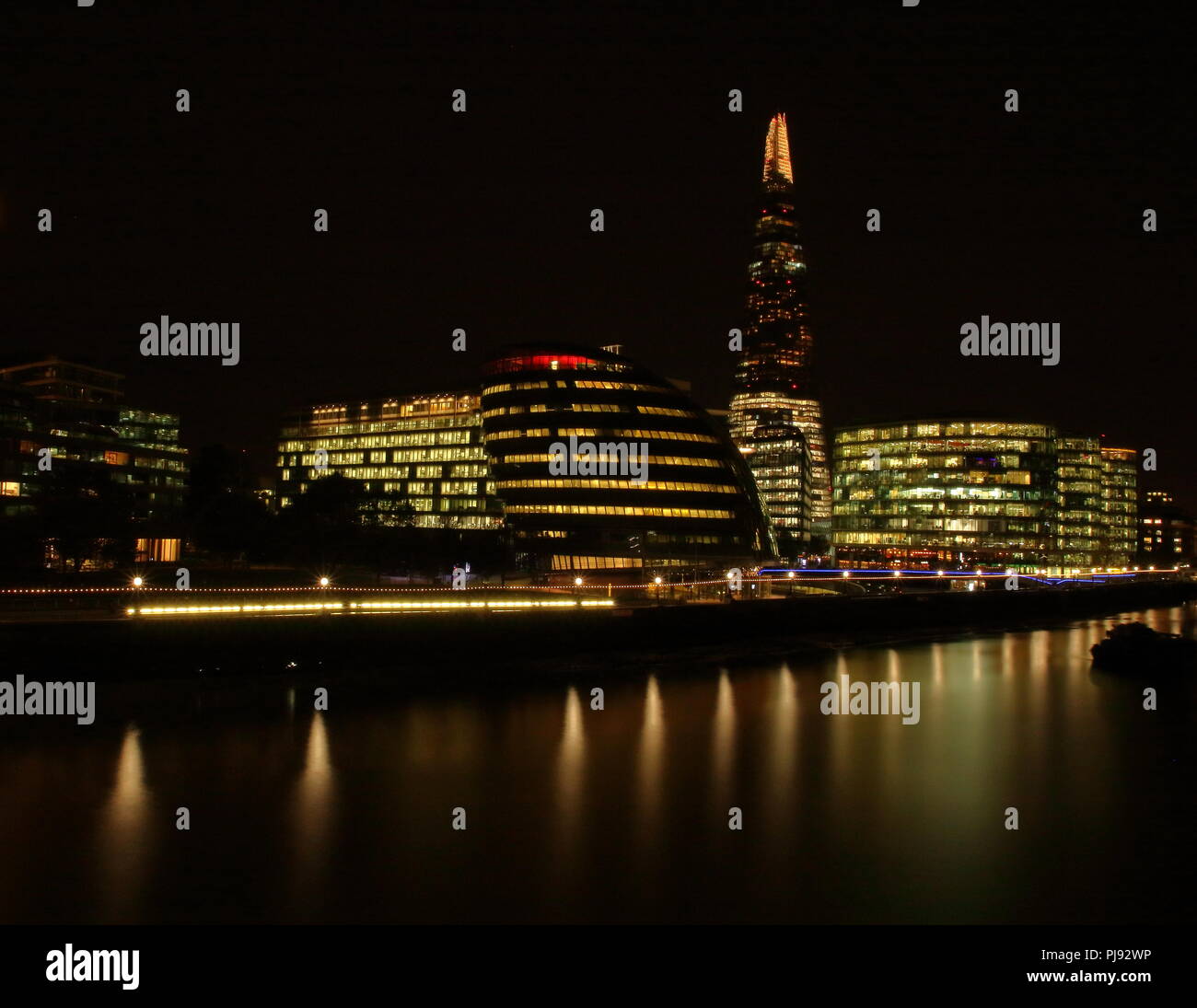 Skyline notturno, paesaggio di Londra, Regno Unito (Gran Bretagna), architettura moderna, terrapieno, il fiume Tamigi e luci della città, riflessi nell'acqua. Foto Stock