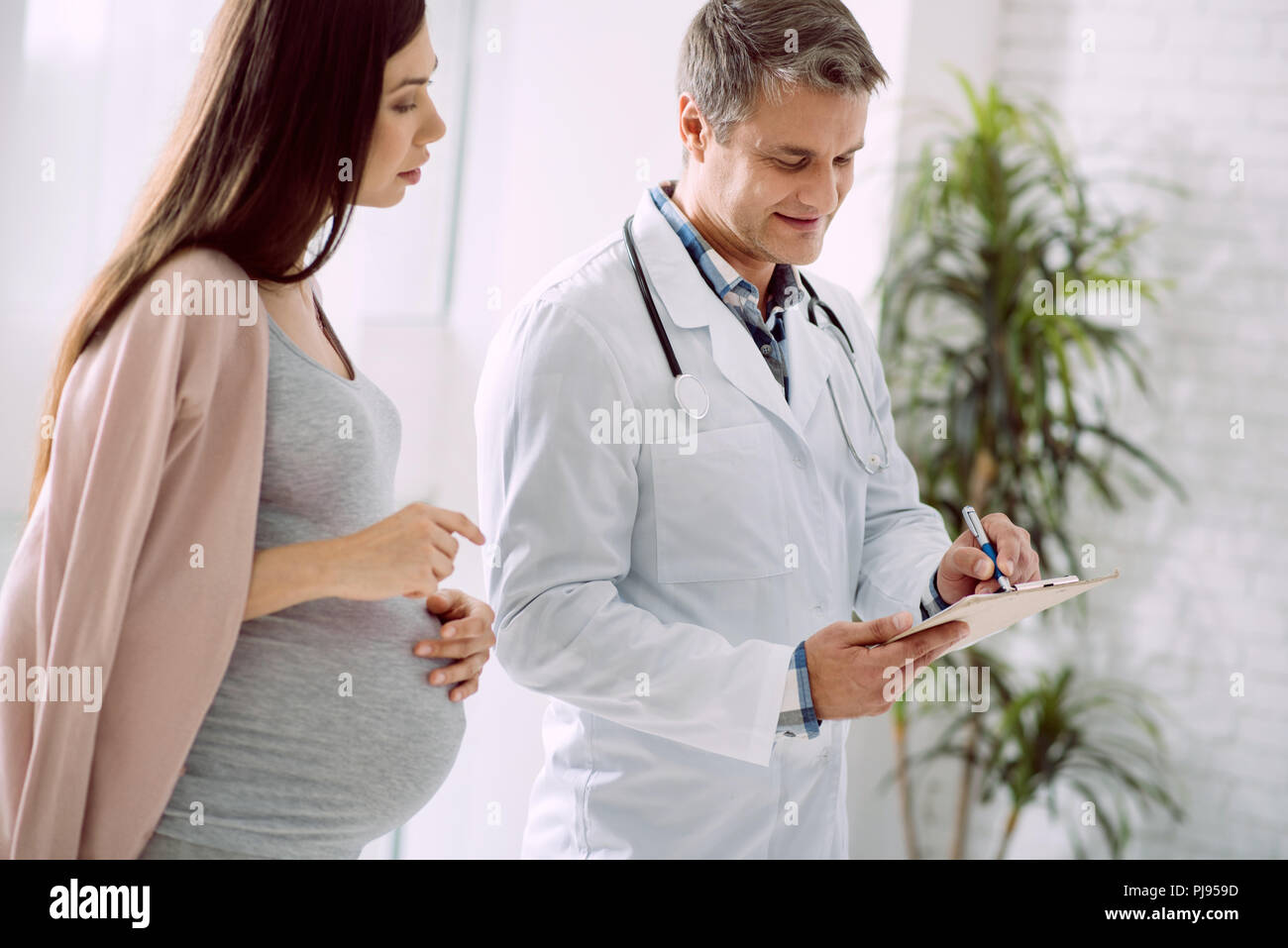 Piacevole donna incinta preoccuparsi per la sua salute Foto Stock