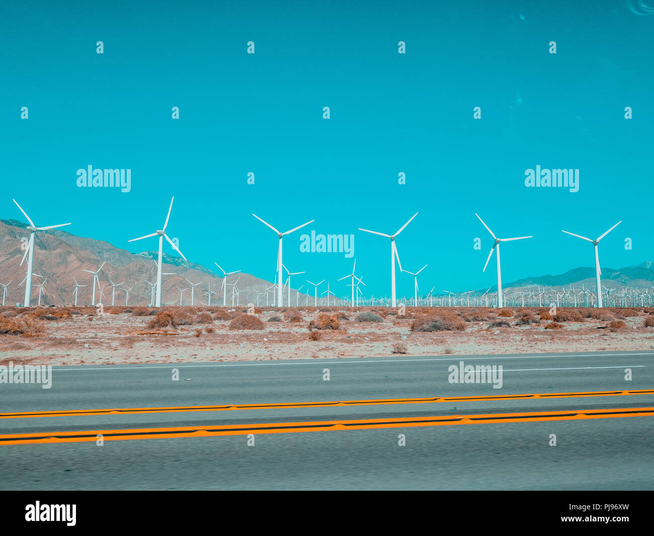 Windmill park in piedi nel deserto lungo l'autostrada Foto Stock